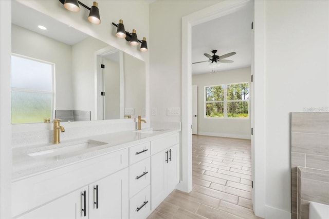 437 Mercedes Ct, Lehigh Acres, FL 33972 - bathroom featuring double vanity, ceiling fan, a tub to relax in, and wood finished floors