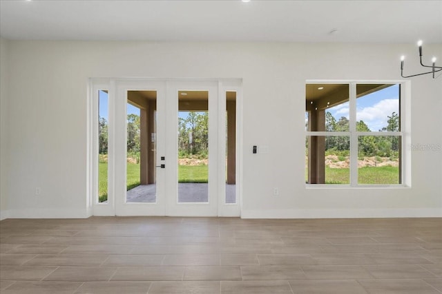 437 Mercedes Ct, Lehigh Acres, FL 33972 - spare room featuring a chandelier, wood finished floors, and french doors