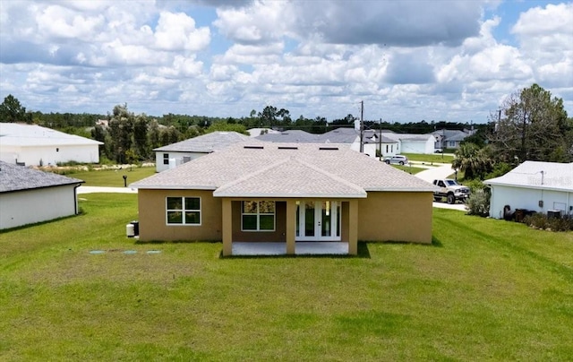 437 Mercedes Ct, Lehigh Acres, FL 33972 - rear view of property featuring a lawn, a patio, roof with shingles, and a residential view