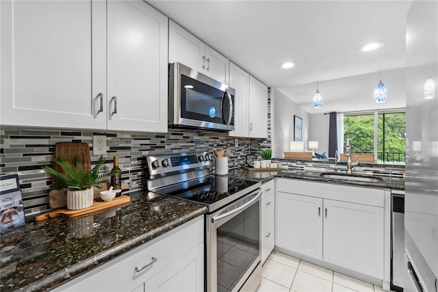 809 Russell Ln Unit 321, Brandon, FL 33510 - kitchen featuring stainless steel appliances, light tile patterned flooring, white cabinetry, decorative backsplash, and recessed lighting