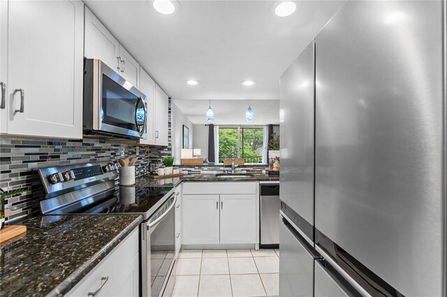809 Russell Ln Unit 321, Brandon, FL 33510 - kitchen featuring stainless steel appliances, light tile patterned floors, backsplash, white cabinets, and recessed lighting