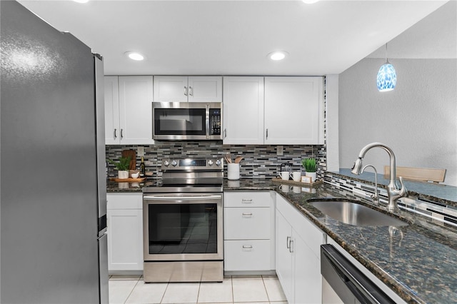 809 Russell Ln Unit 321, Brandon, FL 33510 - kitchen with appliances with stainless steel finishes, decorative backsplash, white cabinetry, and dark stone countertops