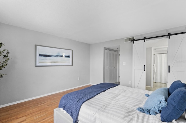 809 Russell Ln Unit 321, Brandon, FL 33510 - bedroom with light wood-type flooring and a barn door