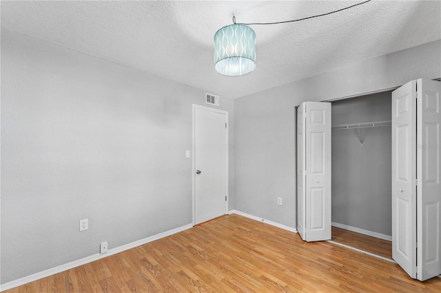 809 Russell Ln Unit 321, Brandon, FL 33510 - unfurnished bedroom featuring light wood-style flooring, a textured ceiling, and a closet