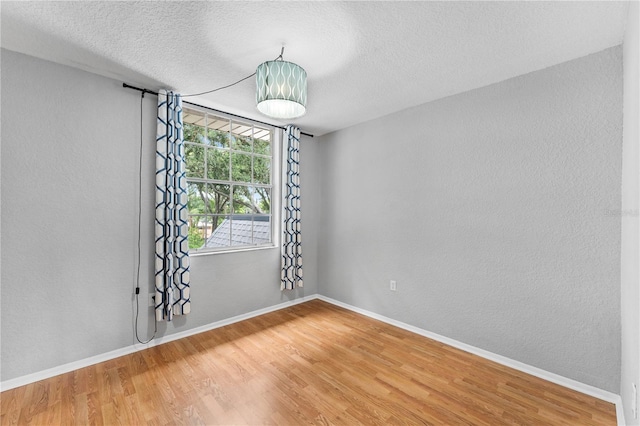 809 Russell Ln Unit 321, Brandon, FL 33510 - spare room featuring wood finished floors, a textured ceiling, and a textured wall