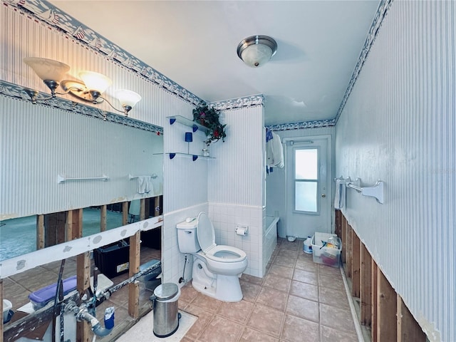 5116 Venetian Blvd NE, Saint Petersburg, FL 33703 - bathroom with wallpapered walls, bathtub / shower combination, tile patterned floors, and wainscoting