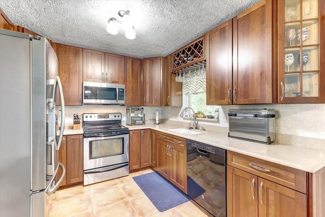 320 Pheasant Cir, Brandon, FL 33510 - kitchen featuring appliances with stainless steel finishes, brown cabinetry, light countertops, and a textured ceiling