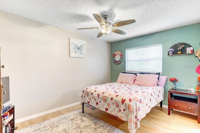 320 Pheasant Cir, Brandon, FL 33510 - bedroom with wood finished floors, a textured ceiling, and a ceiling fan
