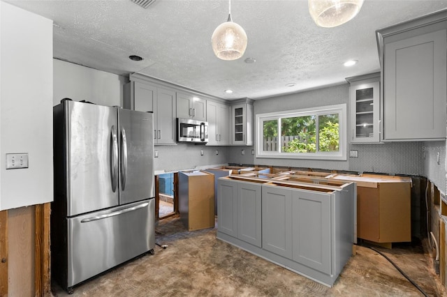 163 Barbados Ave, Tampa, FL 33606 - kitchen with stainless steel appliances, gray cabinetry, a textured ceiling, glass insert cabinets, and hanging light fixtures