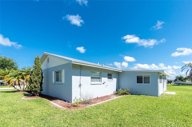 11596 SW Lemon Ave, Arcadia, FL 34269 - rear view of house with stucco siding and a lawn