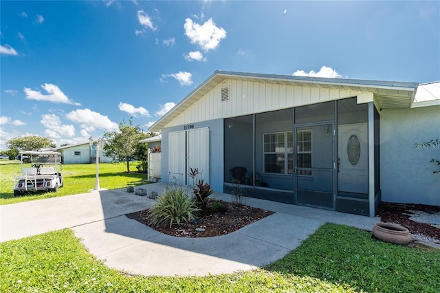 11596 SW Lemon Ave, Arcadia, FL 34269 - view of side of home with a sunroom, a yard, and stucco siding