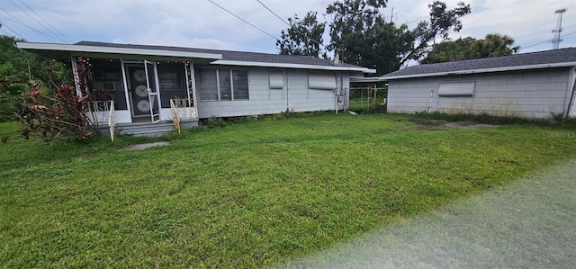 9913 Maggie St, Gibsonton, FL 33534 - back of house with a yard and a sunroom