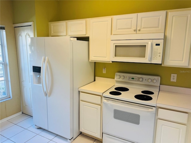 1212 Kennewick Ct, Wesley Chapel, FL 33543 - kitchen featuring white appliances, light countertops, light tile patterned floors, and white cabinetry