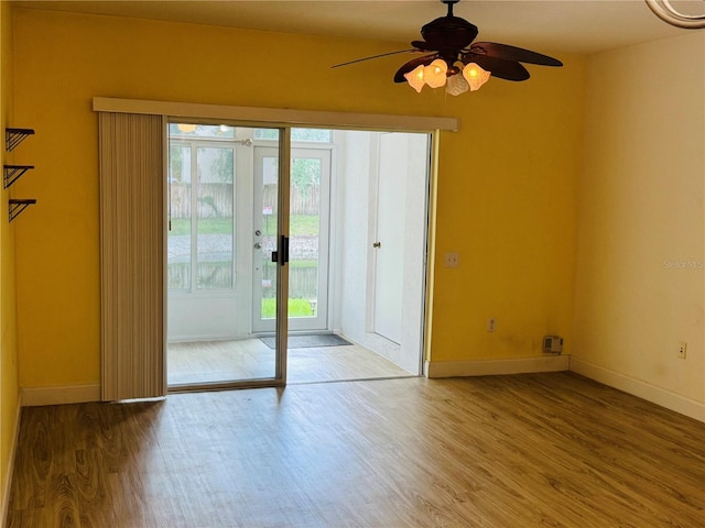 1212 Kennewick Ct, Wesley Chapel, FL 33543 - empty room with wood finished floors, plenty of natural light, ceiling fan, and french doors