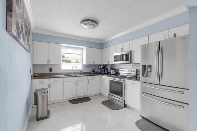 217 Bryan Rd, Brandon, FL 33511 - kitchen featuring appliances with stainless steel finishes, ornamental molding, dark countertops, a textured ceiling, and white cabinets