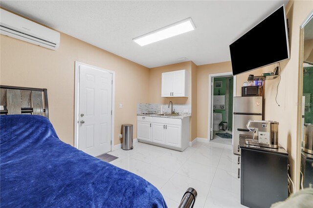 217 Bryan Rd, Brandon, FL 33511 - bedroom featuring a wall mounted AC, light marble finish floors, freestanding refrigerator, and ensuite bathroom
