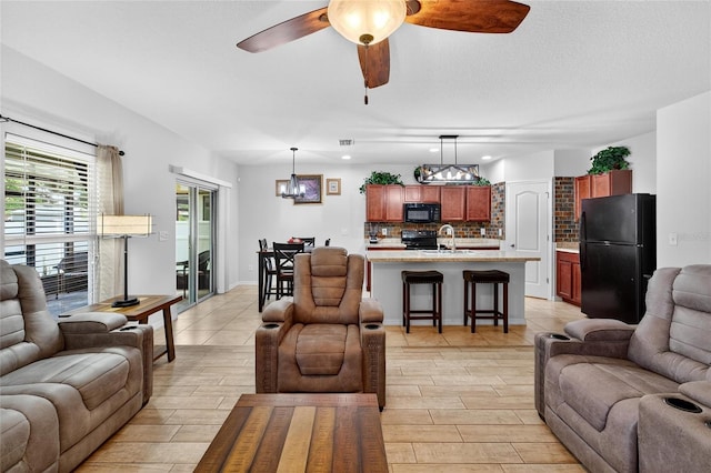 10409 Candleberry Woods Ln, Gibsonton, FL 33534 - living room featuring a chandelier, a ceiling fan, and wood tiled floors