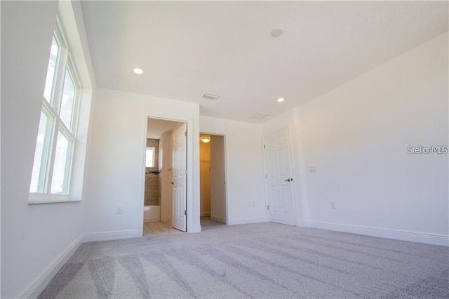 669 Lake Shore Pkwy, Davenport, FL 33896 - unfurnished bedroom featuring light colored carpet, a walk in closet, and recessed lighting