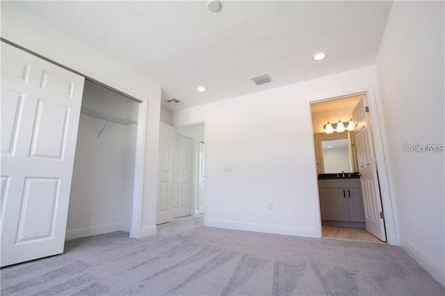 669 Lake Shore Pkwy, Davenport, FL 33896 - unfurnished bedroom with carpet, connected bathroom, a textured ceiling, recessed lighting, and a closet