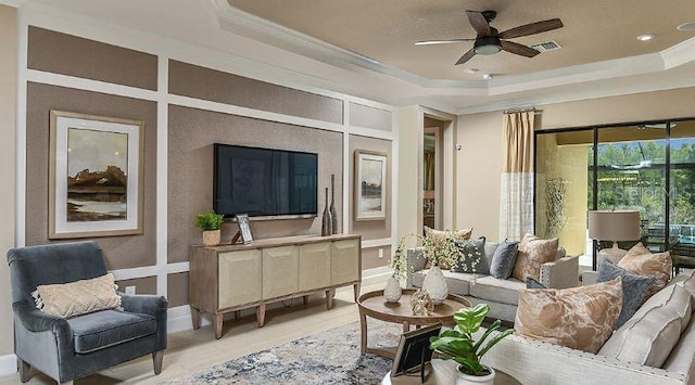 4704 Isonzo Way, Wesley Chapel, FL 33543 - living room with a raised ceiling, a ceiling fan, ornamental molding, and a decorative wall