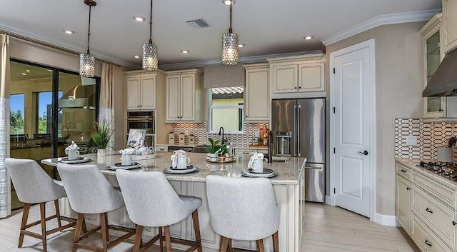 4704 Isonzo Way, Wesley Chapel, FL 33543 - kitchen featuring stainless steel appliances, ornamental molding, a kitchen breakfast bar, decorative backsplash, and a center island with sink