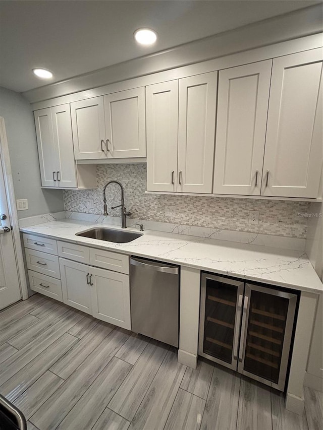 208 Danube Ave Unit 204, Tampa, FL 33606 - kitchen with stainless steel dishwasher, wine cooler, light wood-type flooring, tasteful backsplash, and recessed lighting