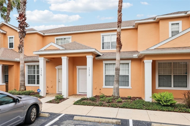 1713 Retreat Cir, Clermont, FL 34714 - view of property with stucco siding, uncovered parking, and a shingled roof