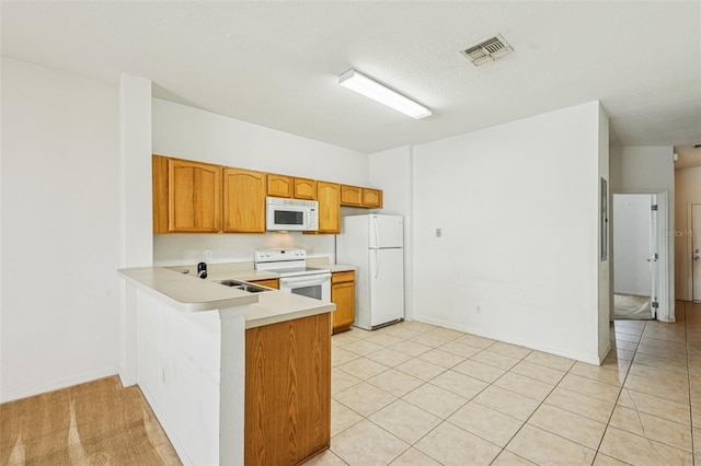 1713 Retreat Cir, Clermont, FL 34714 - kitchen with white appliances, light countertops, a peninsula, light tile patterned flooring, and brown cabinets
