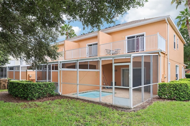 1713 Retreat Cir, Clermont, FL 34714 - back of house featuring a balcony, an outdoor pool, stucco siding, a yard, and a patio