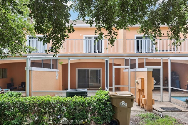 1713 Retreat Cir, Clermont, FL 34714 - rear view of house with a balcony, a patio, stucco siding, and an outdoor pool