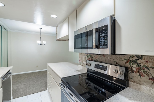 3325 Bayshore Blvd Unit A27, Tampa, FL 33629 - kitchen with stainless steel appliances, light countertops, crown molding, white cabinetry, and light colored carpet