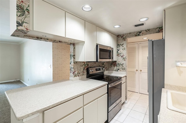 3325 Bayshore Blvd Unit A27, Tampa, FL 33629 - kitchen with appliances with stainless steel finishes, light countertops, ornamental molding, white cabinets, and light tile patterned flooring