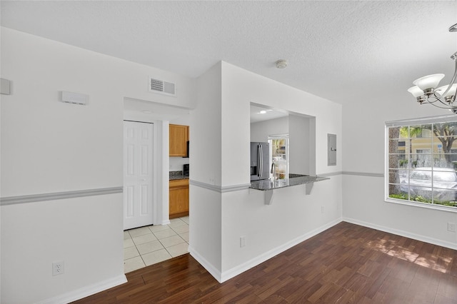 10737 Keys Gate Dr, Riverview, FL 33579 - spare room with electric panel, wood finished floors, a textured ceiling, and a chandelier