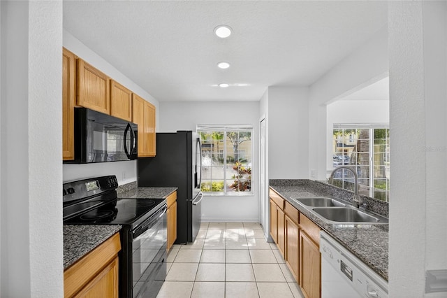 10737 Keys Gate Dr, Riverview, FL 33579 - kitchen with black appliances, dark stone counters, light tile patterned floors, and recessed lighting