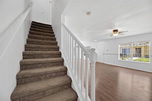 10737 Keys Gate Dr, Riverview, FL 33579 - stairs featuring wood finished floors, ceiling fan, and a textured ceiling