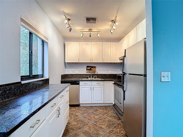 11718 Raintree Village Blvd Unit C, Temple Terrace, FL 33617 - kitchen featuring appliances with stainless steel finishes, white cabinets, tile counters, and a textured wall