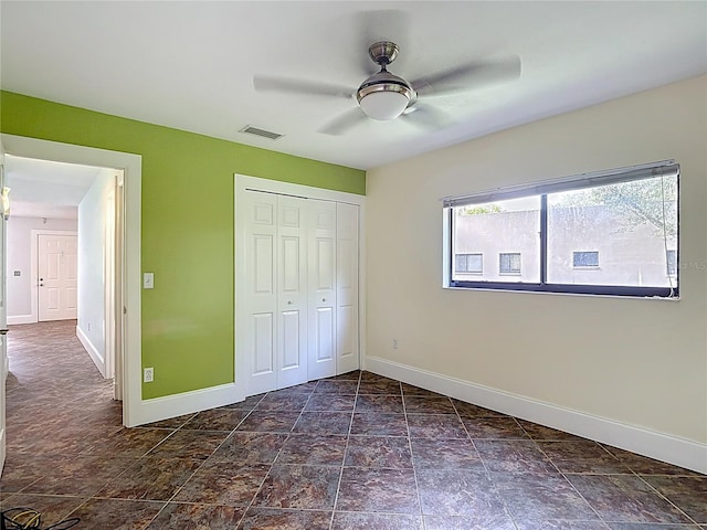 11718 Raintree Village Blvd Unit C, Temple Terrace, FL 33617 - unfurnished bedroom with a closet, a ceiling fan, and dark stone finish flooring