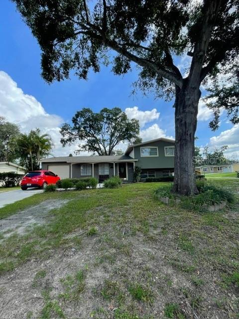 408 Blueberry Ln, Brandon, FL 33510 - tri-level home featuring a garage