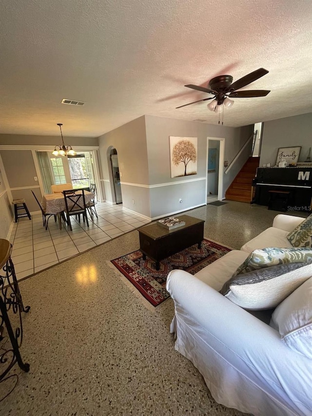 408 Blueberry Ln, Brandon, FL 33510 - living area featuring arched walkways, a textured ceiling, speckle patterned floor, stairway, and a ceiling fan