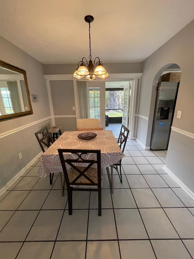 408 Blueberry Ln, Brandon, FL 33510 - dining space featuring light tile patterned floors, a chandelier, and arched walkways