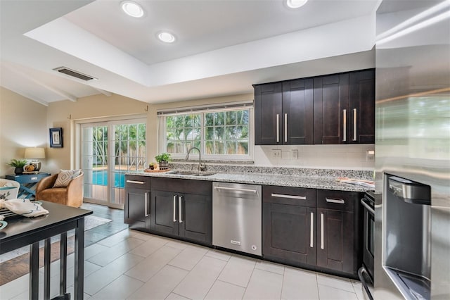 13521 Del Prado Dr S, Largo, FL 33774 - kitchen featuring stainless steel appliances, healthy amount of natural light, light stone countertops, decorative backsplash, and recessed lighting