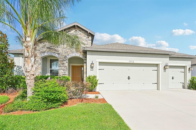 11713 Tetrafin Dr, Riverview, FL 33579 - view of front of house featuring a garage, stone siding, concrete driveway, and stucco siding