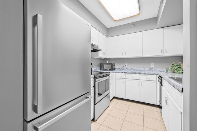 2333 Feather Sound Dr Unit B208, Clearwater, FL 33762 - kitchen with appliances with stainless steel finishes, white cabinetry, light tile patterned flooring, and under cabinet range hood
