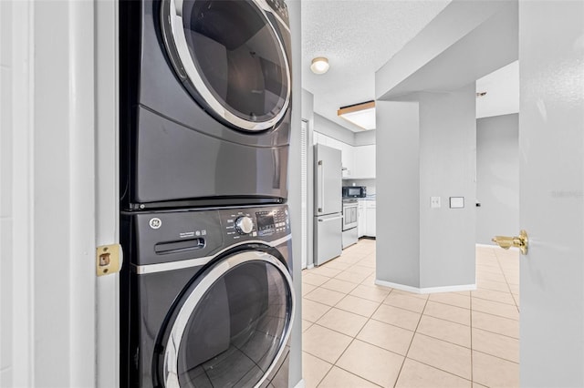 2333 Feather Sound Dr Unit B208, Clearwater, FL 33762 - laundry area featuring stacked washing machine and dryer, light tile patterned flooring, and a textured ceiling