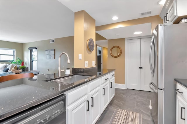 4141 Bayshore Blvd Unit 304, Tampa, FL 33611 - kitchen with freestanding refrigerator, dishwashing machine, dark stone countertops, white cabinets, and open floor plan