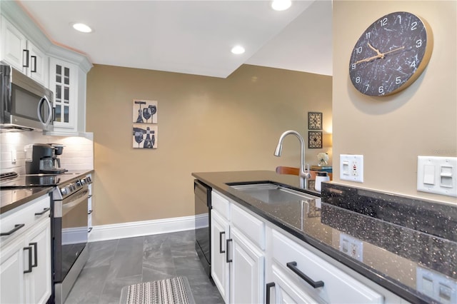 4141 Bayshore Blvd Unit 304, Tampa, FL 33611 - kitchen featuring appliances with stainless steel finishes, white cabinetry, backsplash, glass insert cabinets, and dark stone counters
