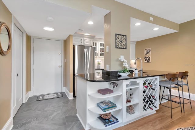 4141 Bayshore Blvd Unit 304, Tampa, FL 33611 - kitchen with open shelves, dark countertops, a kitchen bar, glass insert cabinets, and white cabinets