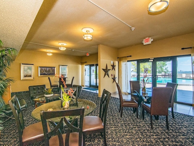4141 Bayshore Blvd Unit 304, Tampa, FL 33611 - dining area with a textured ceiling, plenty of natural light, carpet floors, and french doors