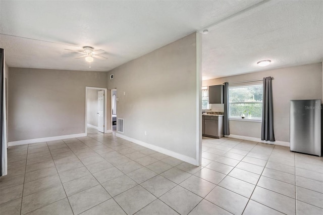 15008 Spokane Rd, Spring Hill, FL 34610 - empty room featuring light tile patterned floors, ceiling fan, and a textured ceiling