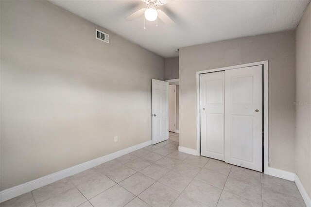 15008 Spokane Rd, Spring Hill, FL 34610 - unfurnished bedroom with a closet, light tile patterned floors, and a ceiling fan